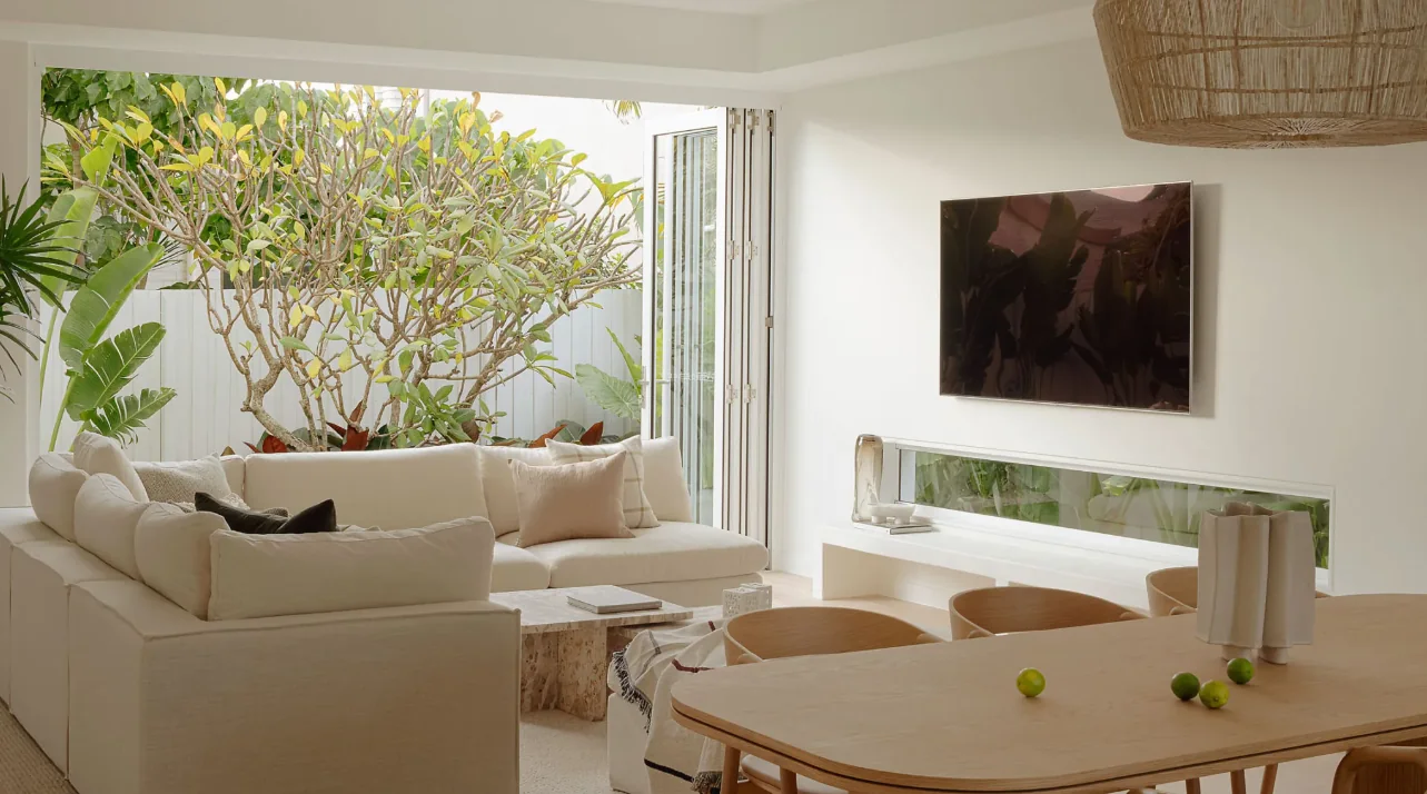 Aluminium bi-fold doors folded open from a lounge room to a garden courtyard