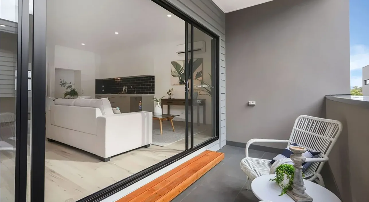 Aluminium sliding glass doors opening a dining room onto a timber deck
