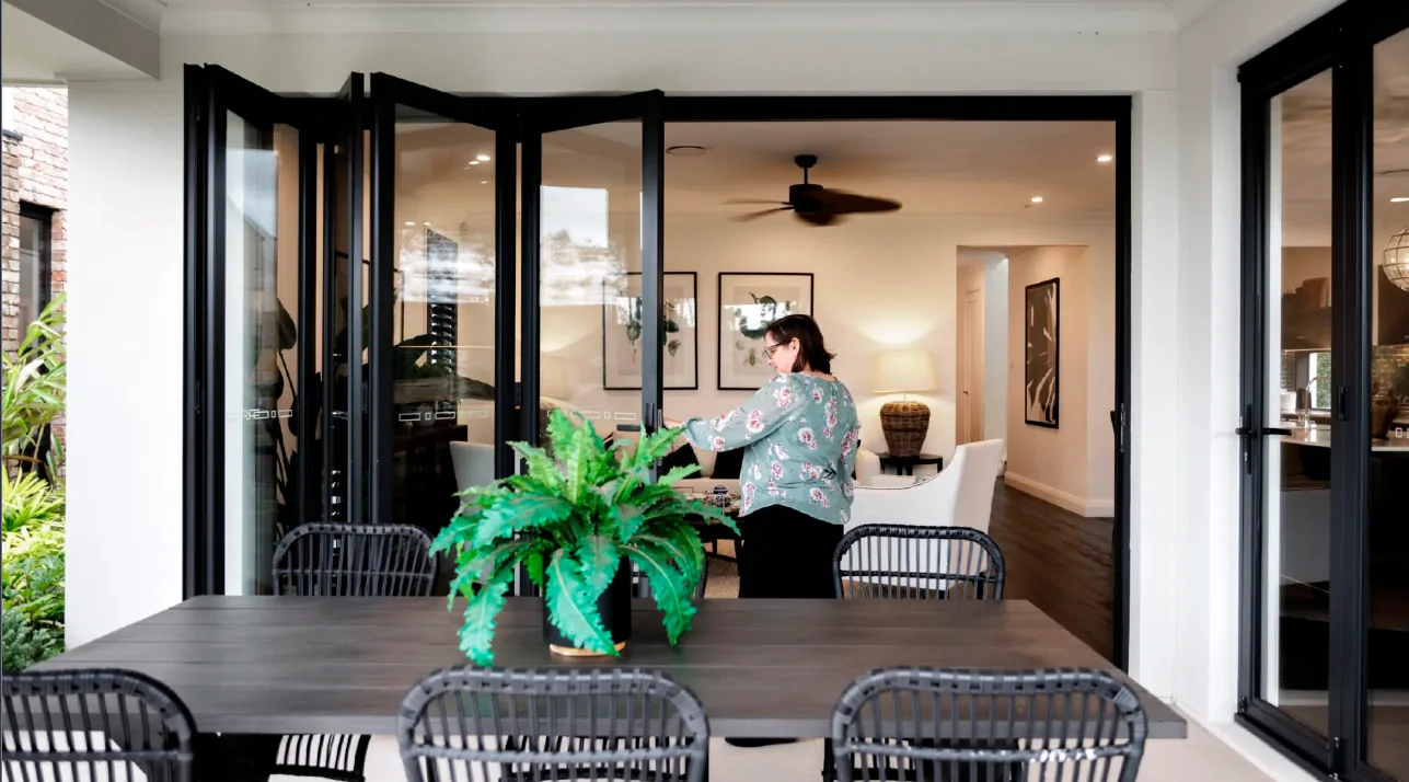 Black aluminium bi-fold doors opening a dining area to a courtyard