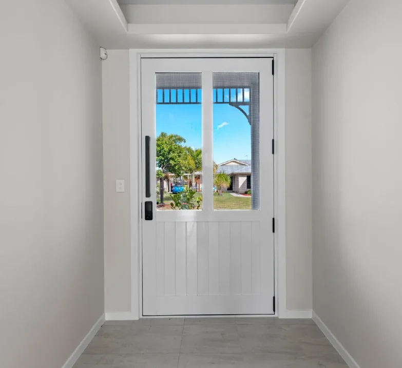 White entrance door with glass panels in a residential hallway