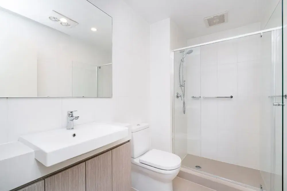 Glass shower screen and wall mirror in a bright bathroom
