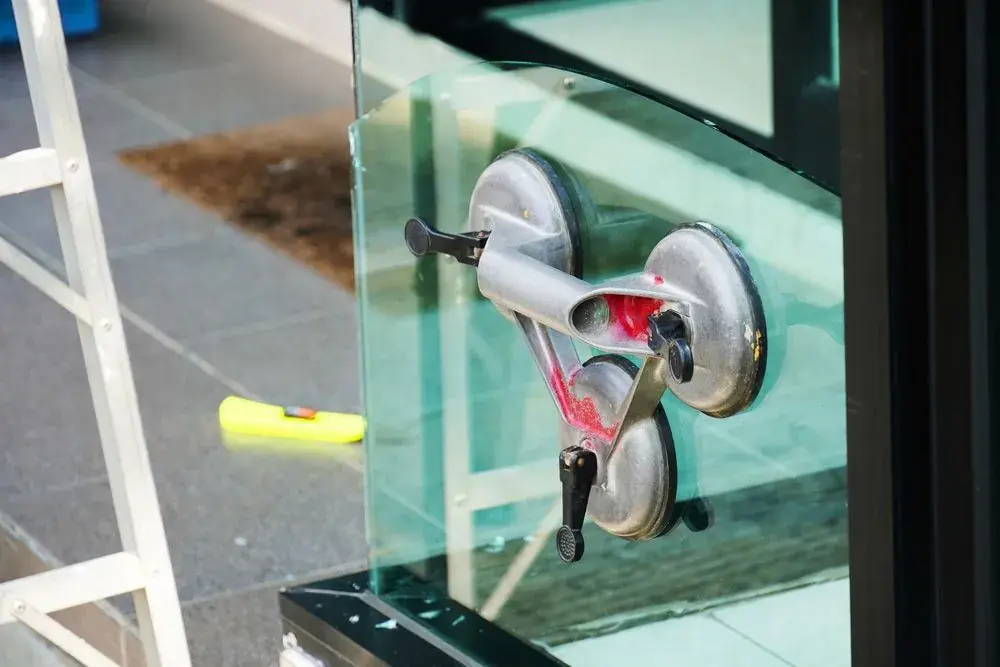 Glass panel being positioned with suction lifting handles