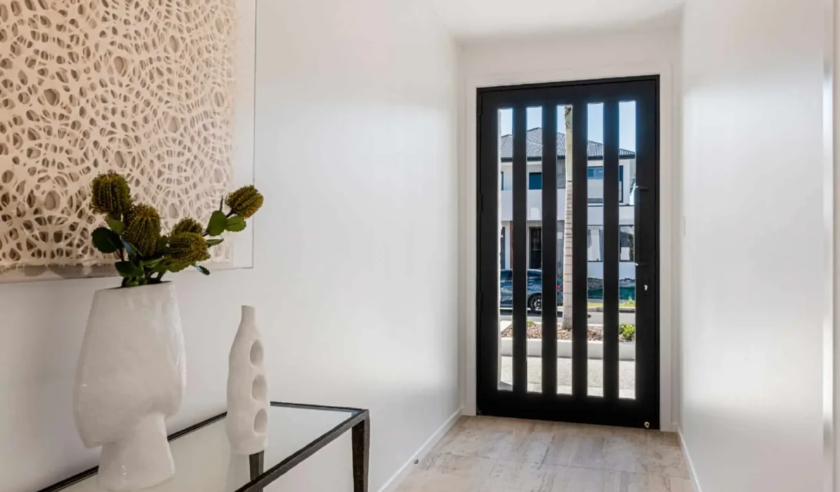 Black aluminium framed entrance door with narrow glass panels in a hallway
