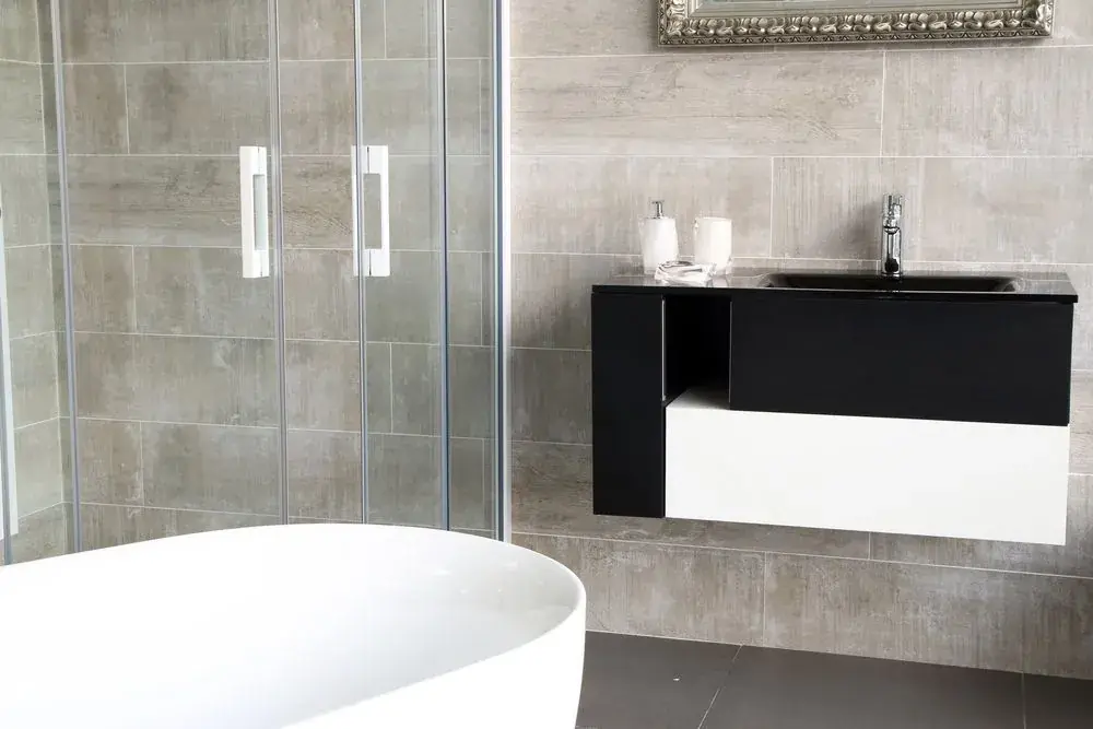 Glass shower enclosure beside a freestanding bath