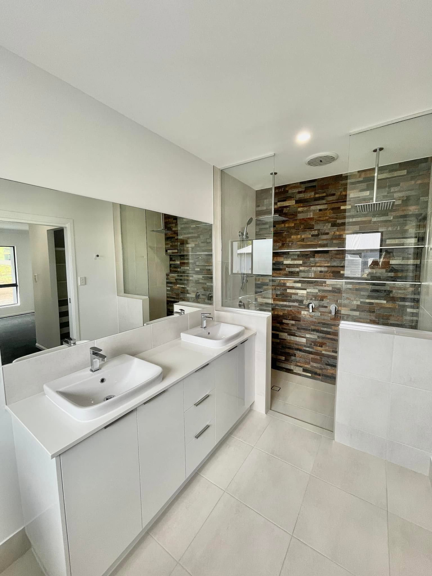 Frameless glass shower screen and wall mirrors in a Bowen bathroom glazed by Dreger Glass & Aluminium